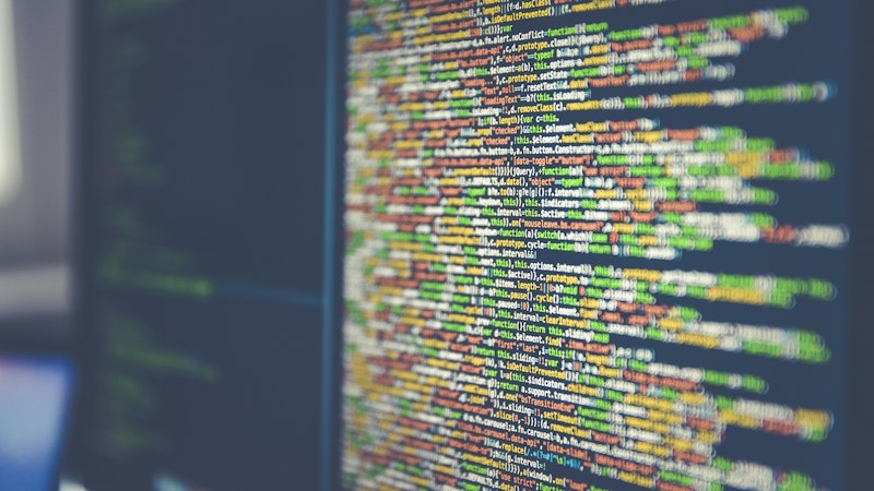 Lines of code on a monitor, representing the plain, unfashionable software stack behind a set of production websites