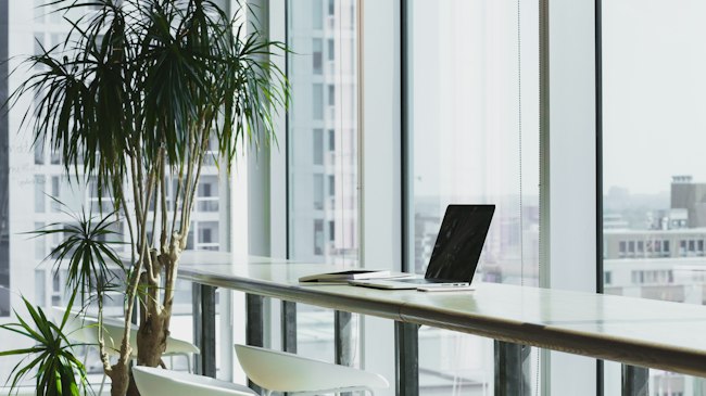 A person working at a desk with a laptop and phone