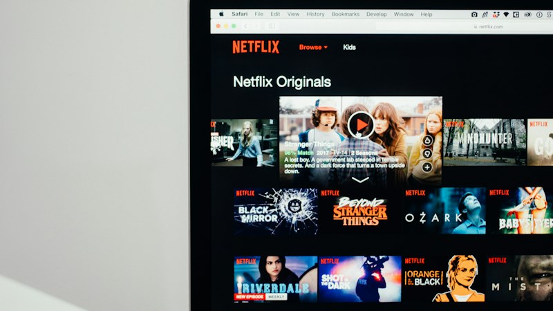 A laptop screen showing a streaming service browse page, the kind of movie night screen that is hard to keep in sync across two different devices