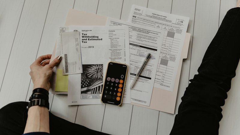 A calculator resting on financial documents, representing the surprise cost of running AI agents in production